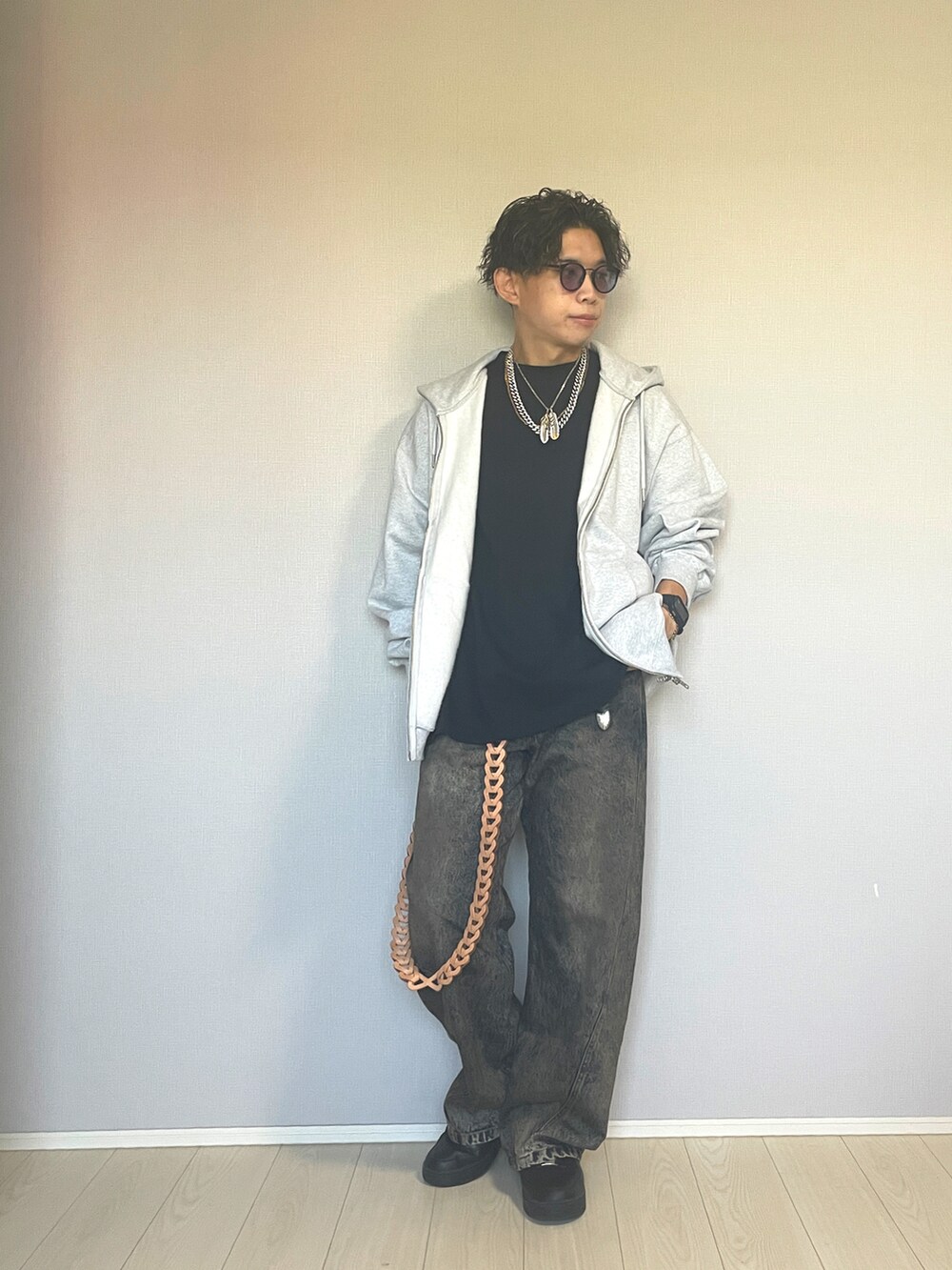 ブラック系のスニーカー、ブルー系のデニムパンツ、グレー系のパーカーを着用したメンズの秋コーディネートの2枚目の写真