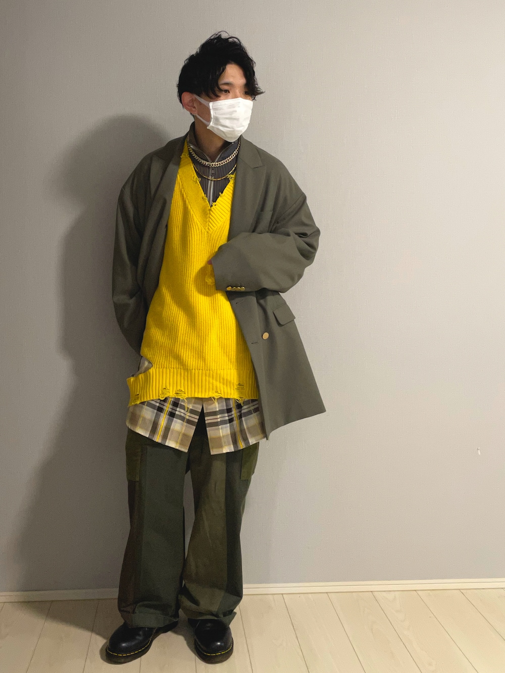 ブラック系のシューズ、グリーン系のカーゴパンツ、イエロー系のニット/セーターを着用したメンズの冬コーディネートの2枚目の写真