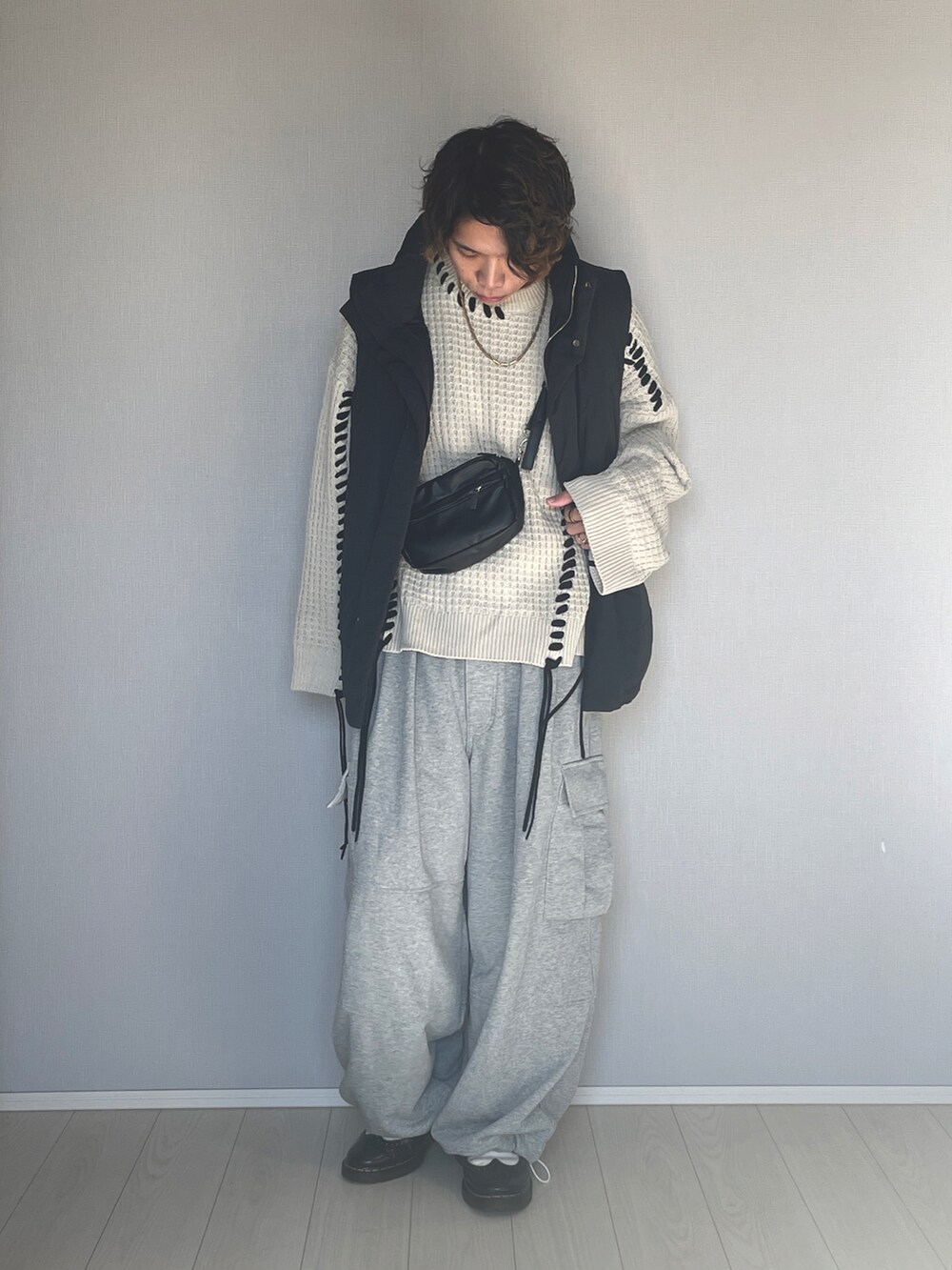 ブラック系のダウンベスト、グレー系のスウェットパンツ、ブラック系のシューズを着用したメンズの冬コーディネートの2枚目の写真