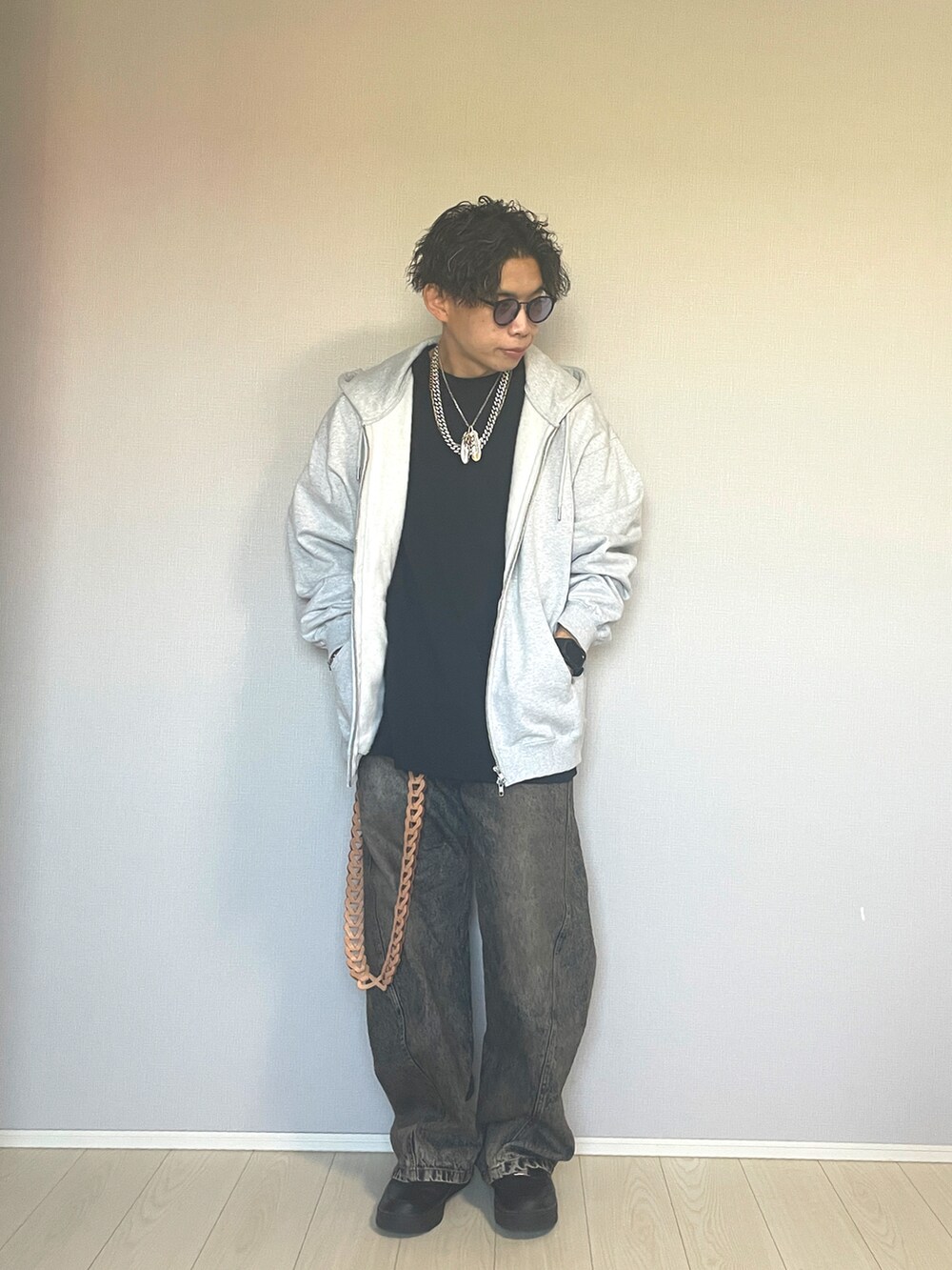 ブラック系のスニーカー、ブルー系のデニムパンツ、グレー系のパーカーを着用したメンズの秋コーディネートの3枚目の写真