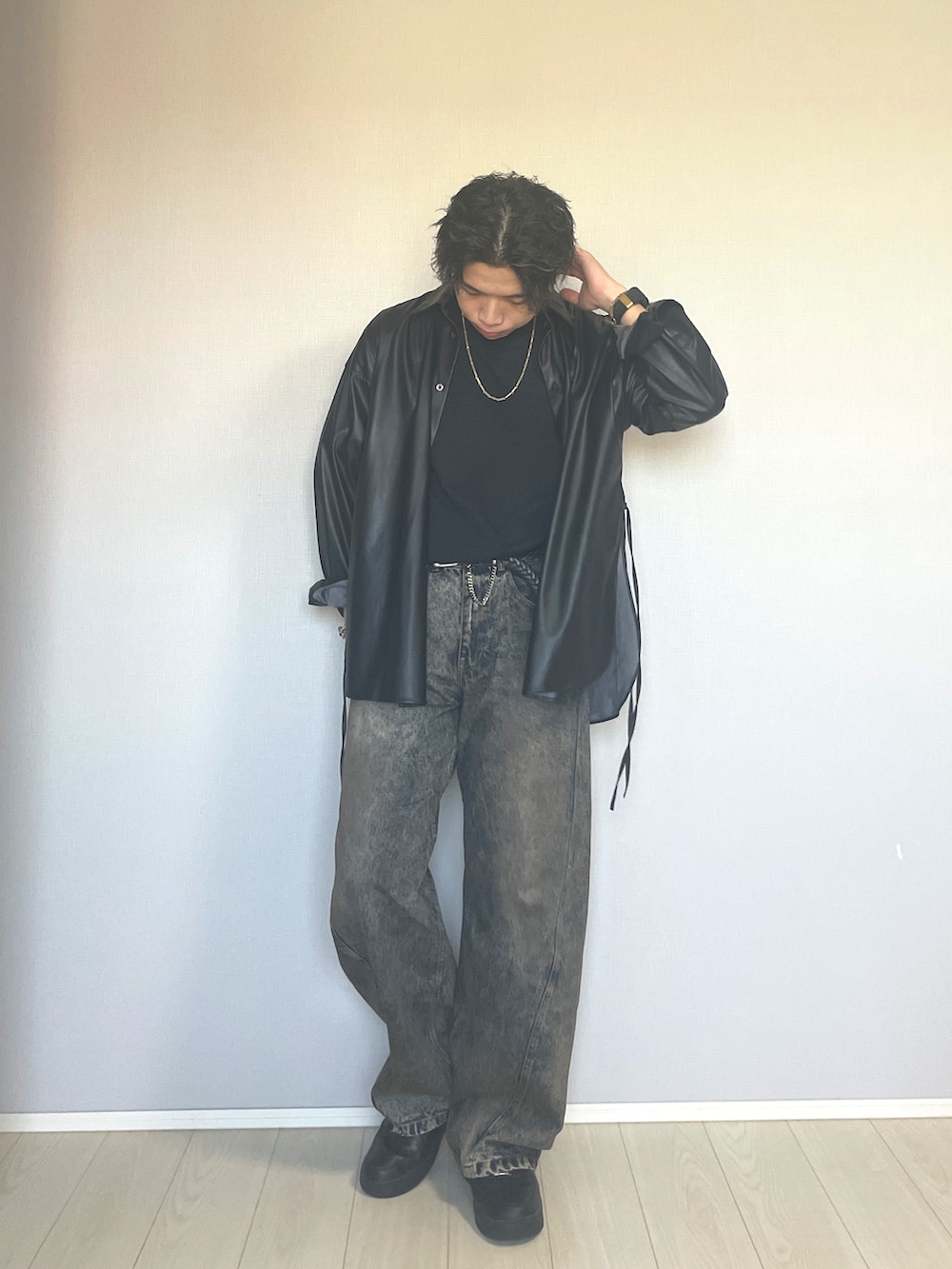 ブラック系のスニーカー、ブルー系のデニムパンツ、ブラック系のTシャツ/カットソーを着用したメンズの秋コーディネートの4枚目の写真