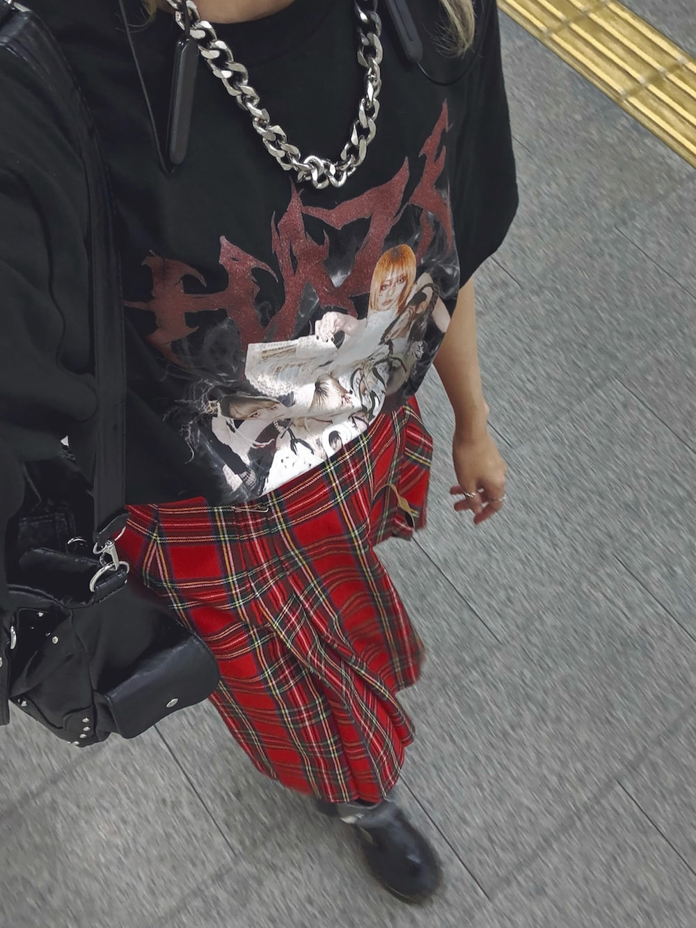 ブラック系のデニムパンツ、ブラック系のローファー、レッド系のスカートを着用したレディースの冬コーディネートの2枚目の写真