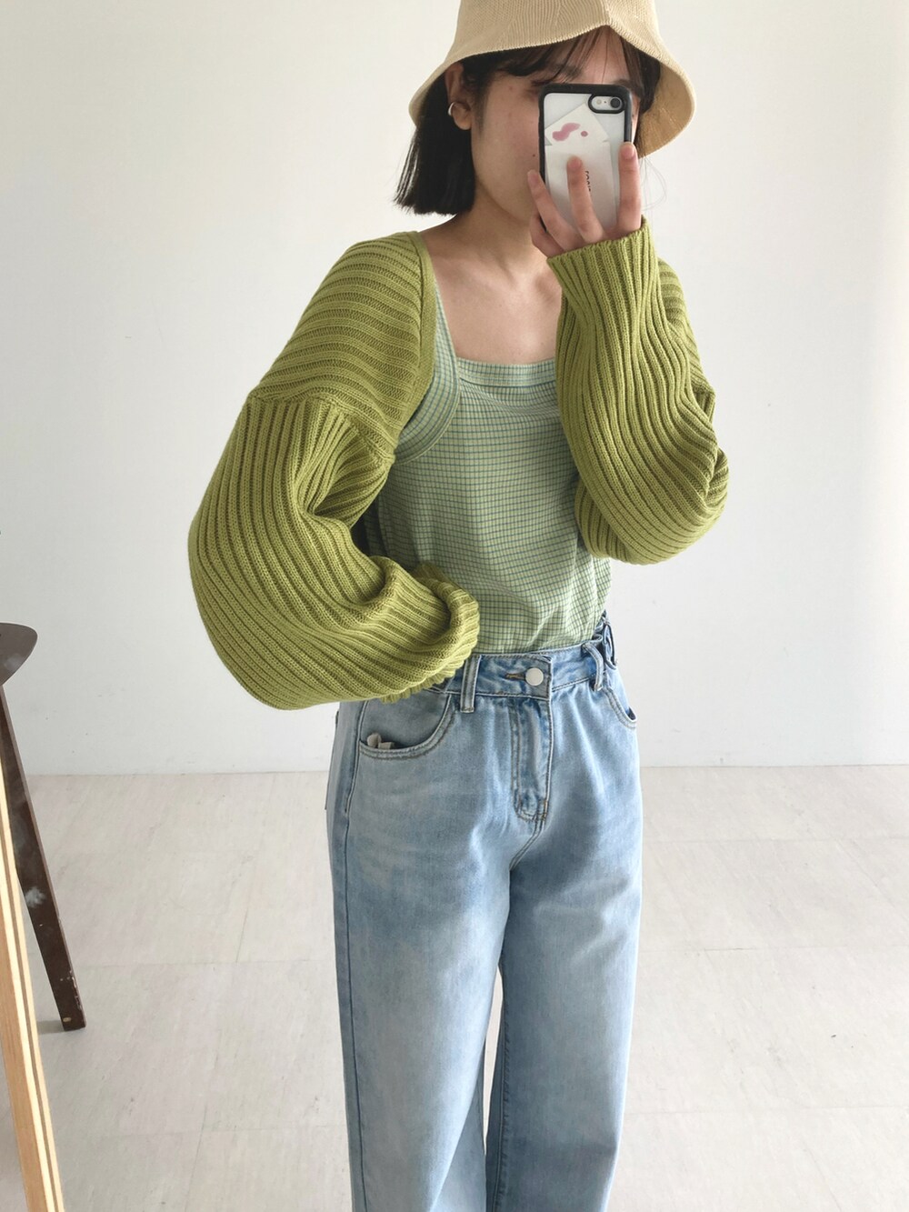 グリーン系のカーディガン/ボレロ、ブルー系のデニムパンツ、ベージュ系のバッグを着用したレディースの春コーディネートの4枚目の写真