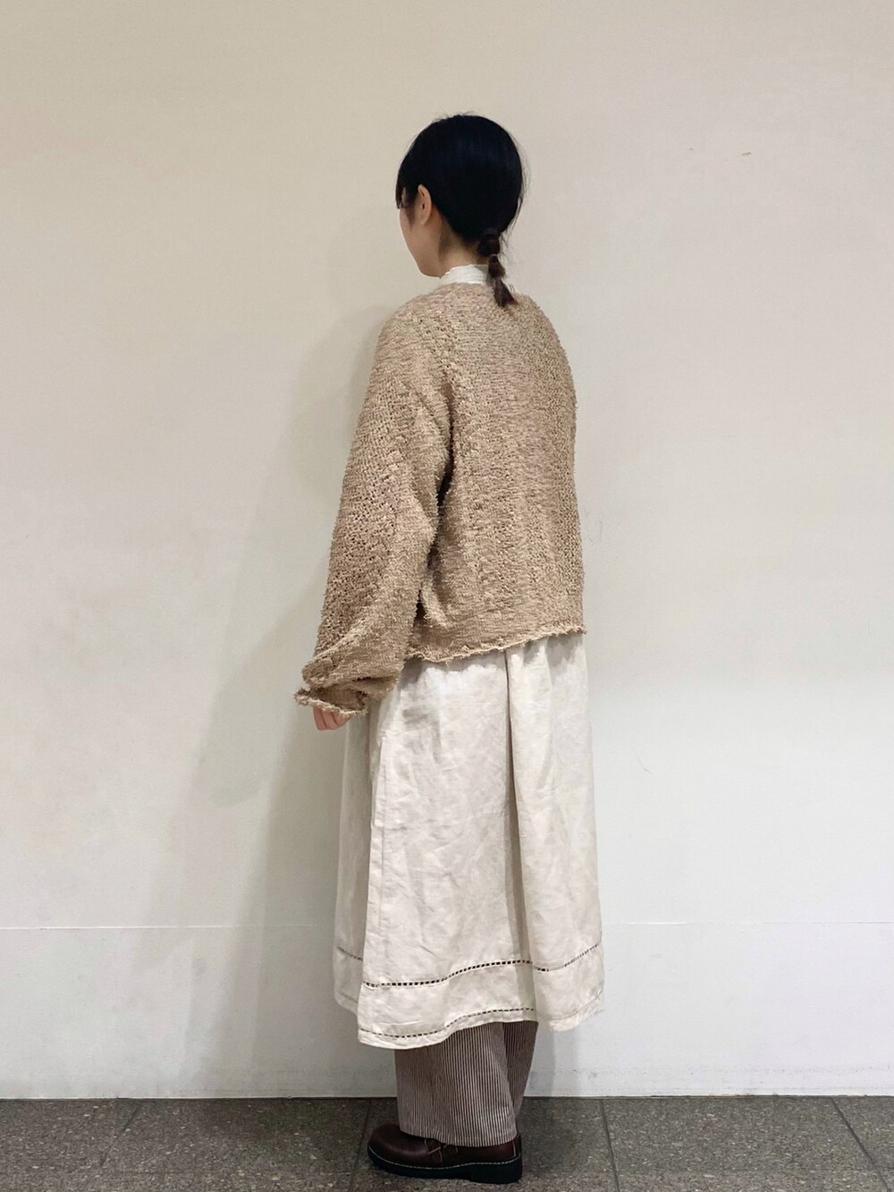 ブラウン系のその他パンツ、ベージュ系のカーディガン/ボレロ、グレー系のワンピースを着用したレディースの冬コーディネートの2枚目の写真