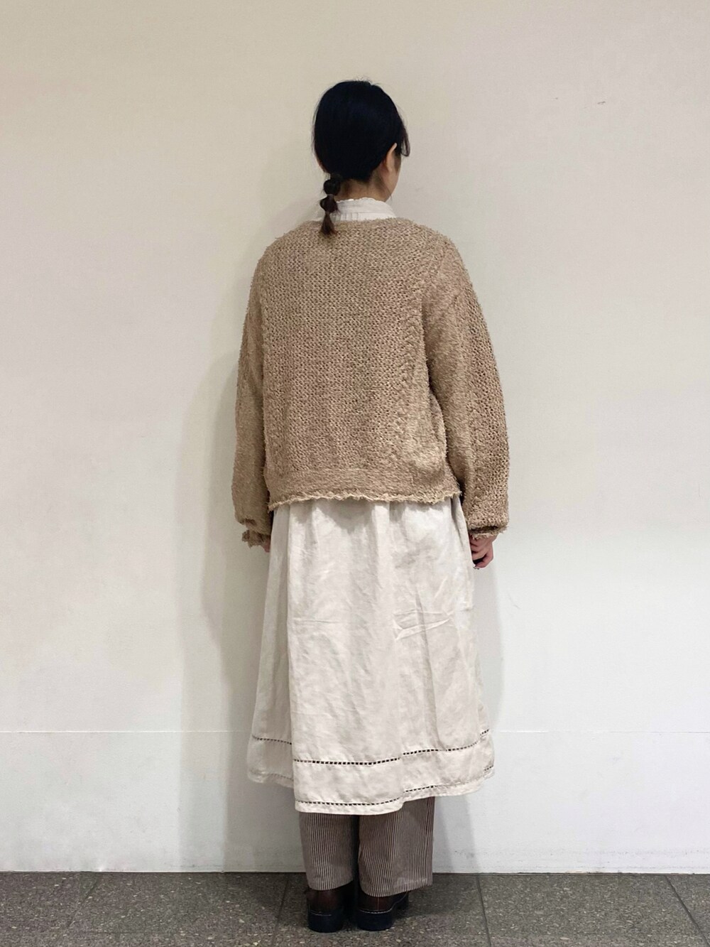 ブラウン系のその他パンツ、ベージュ系のカーディガン/ボレロ、グレー系のワンピースを着用したレディースの冬コーディネートの3枚目の写真