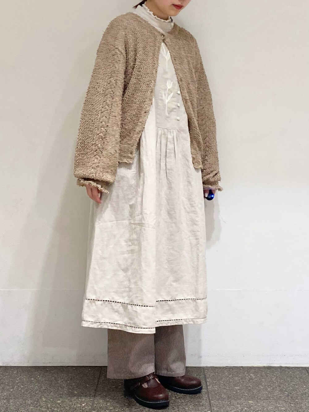ブラウン系のその他パンツ、ベージュ系のカーディガン/ボレロ、グレー系のワンピースを着用したレディースの冬コーディネートの5枚目の写真