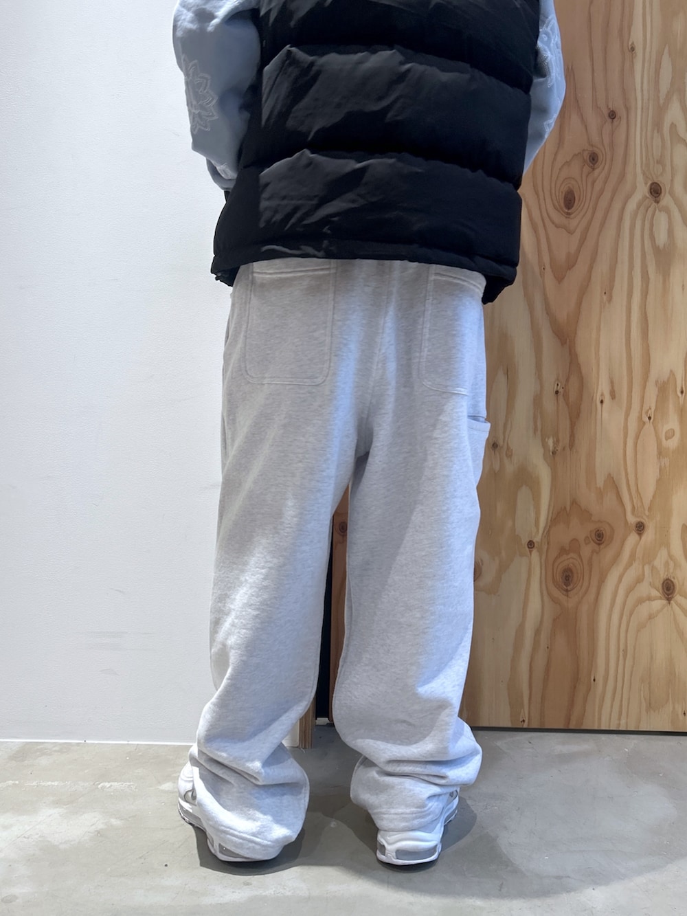 ブラック系のダウンベスト、ブルー系のパーカー、グレー系のスウェットパンツを着用したメンズの秋コーディネートの5枚目の写真