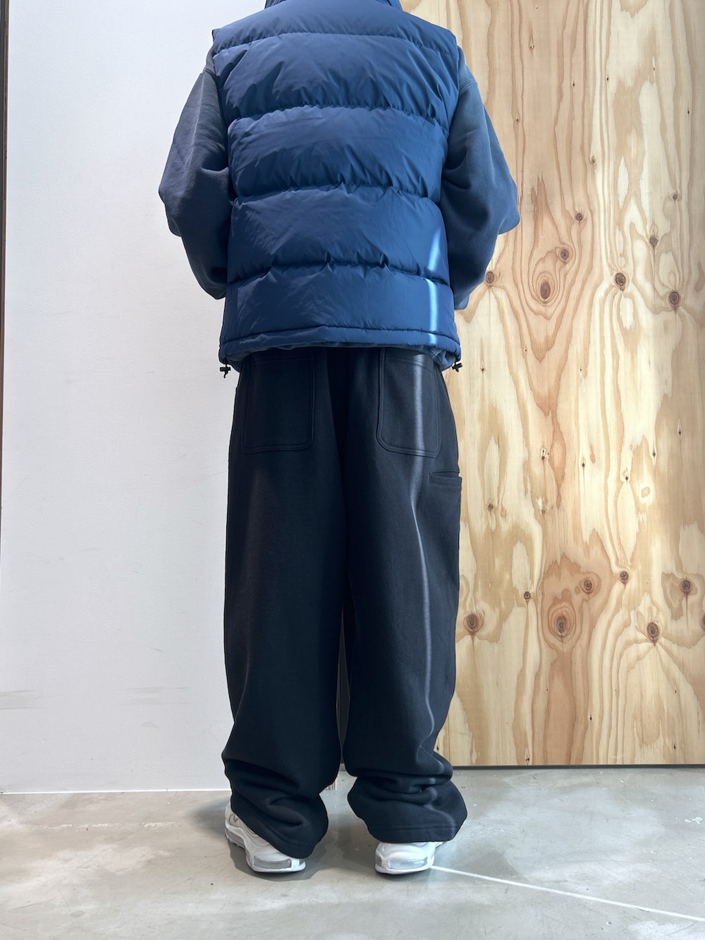 ブルー系のパーカー、ブルー系のベスト、ブラック系のスウェットパンツを着用したメンズの冬コーディネートの3枚目の写真