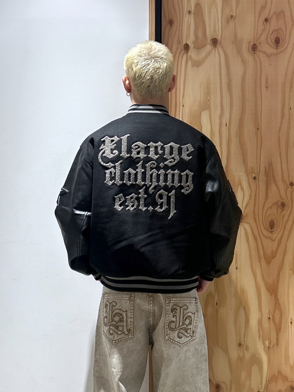 ブラック系のスタジャン、ベージュ系のデニムパンツを着用したメンズの秋コーディネートの3枚目の写真