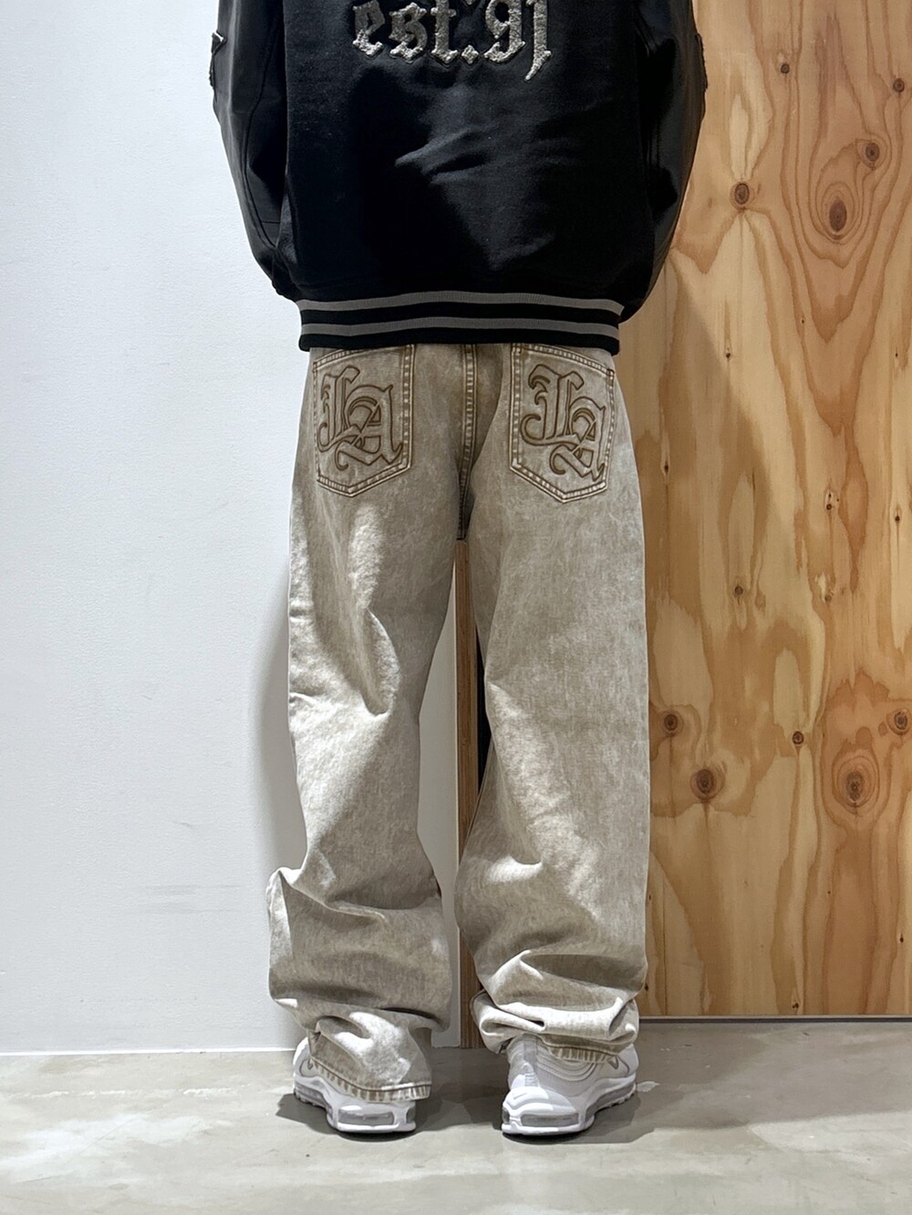 ブラック系のスタジャン、ベージュ系のデニムパンツを着用したメンズの秋コーディネートの5枚目の写真