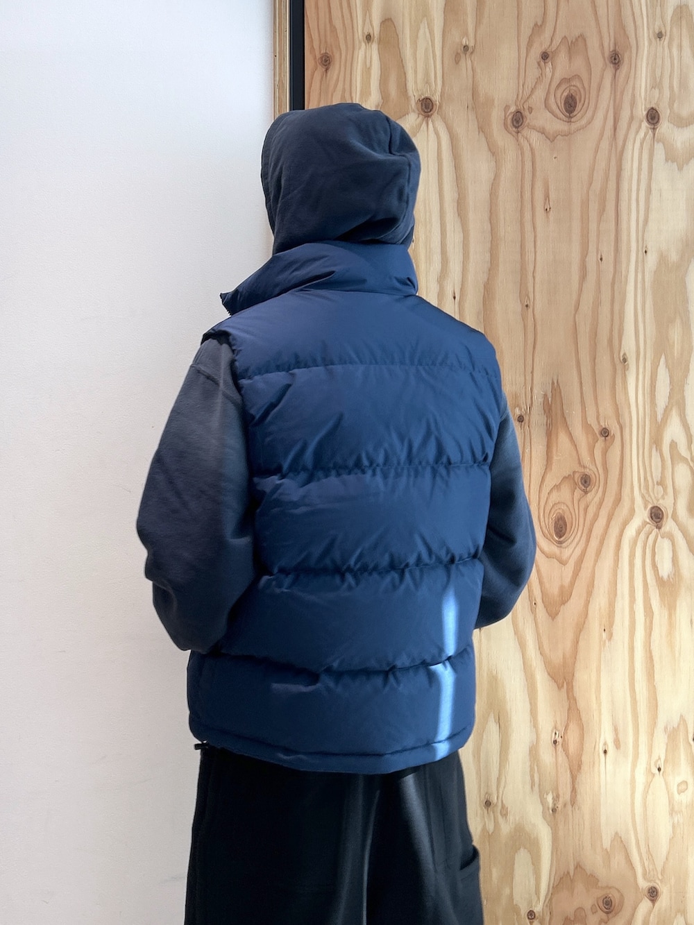 ブルー系のパーカー、ブルー系のベスト、ブラック系のスウェットパンツを着用したメンズの冬コーディネートの4枚目の写真