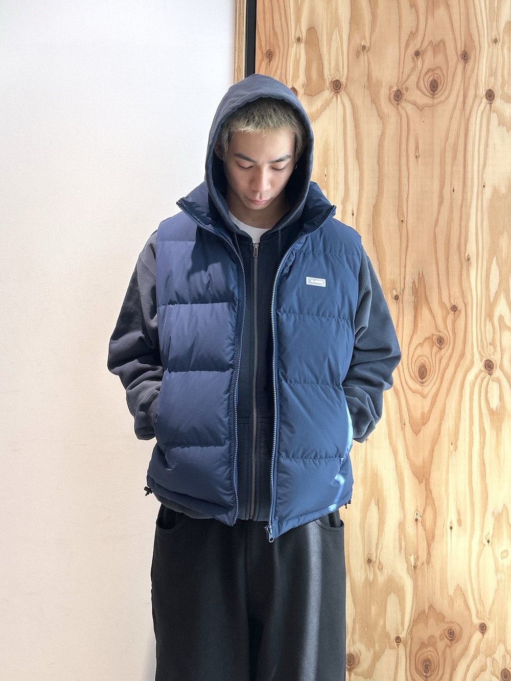 ブルー系のパーカー、ブルー系のベスト、ブラック系のスウェットパンツを着用したメンズの冬コーディネートの2枚目の写真