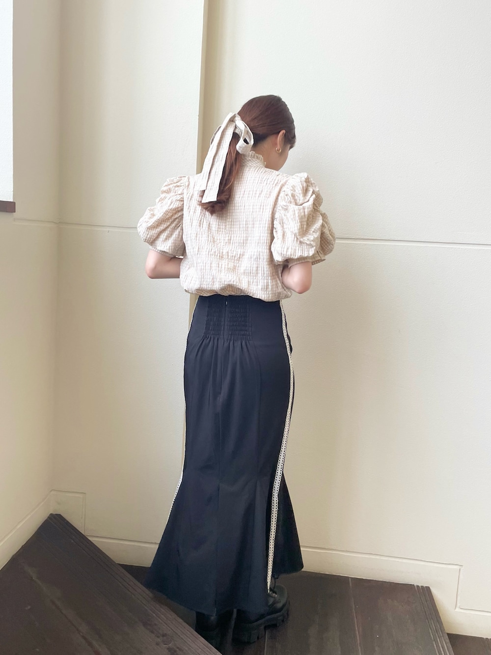 ベージュ系のシャツ/ブラウス、ブラック系のブーツ、ブラック系のスカートを着用したレディースの夏コーディネートの2枚目の写真