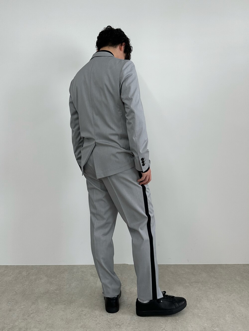 グレー系のテーラードジャケット、グレー系のスラックス、ブラック系のシャツ/ブラウスを着用したメンズの春コーディネートの3枚目の写真