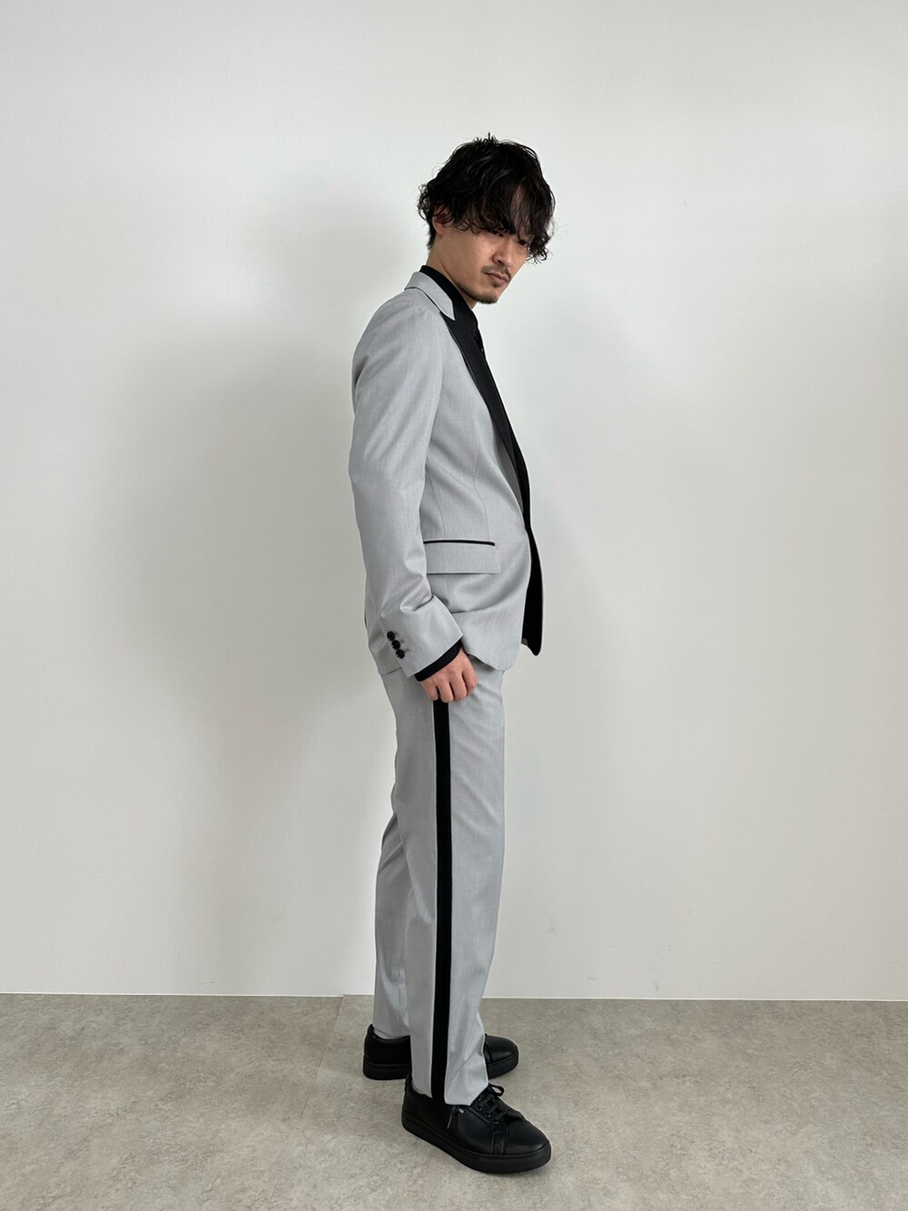 グレー系のテーラードジャケット、グレー系のスラックス、ブラック系のシャツ/ブラウスを着用したメンズの春コーディネートの4枚目の写真