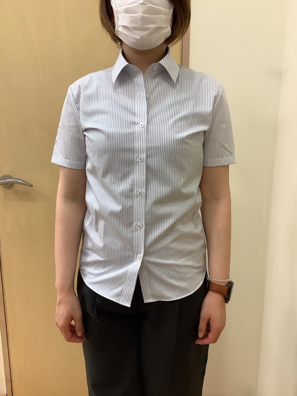 グレー系のビジネスシャツ、ブラック系のスラックス、ブラック系のスリッポンを着用したレディースの夏コーディネートの3枚目の写真