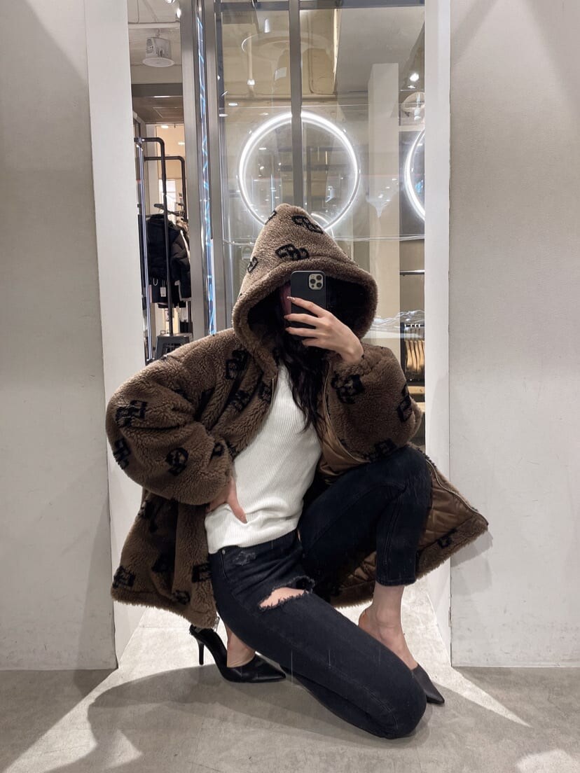 ブラック系のパンプス、ブラック系のデニムパンツ、ホワイト系のニット/セーターを着用したレディースの秋コーディネートの3枚目の写真