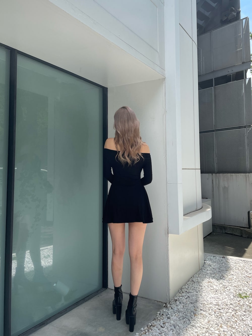 ブラック系のワンピース、ブラック系のブーツを着用したレディースの夏コーディネートの4枚目の写真