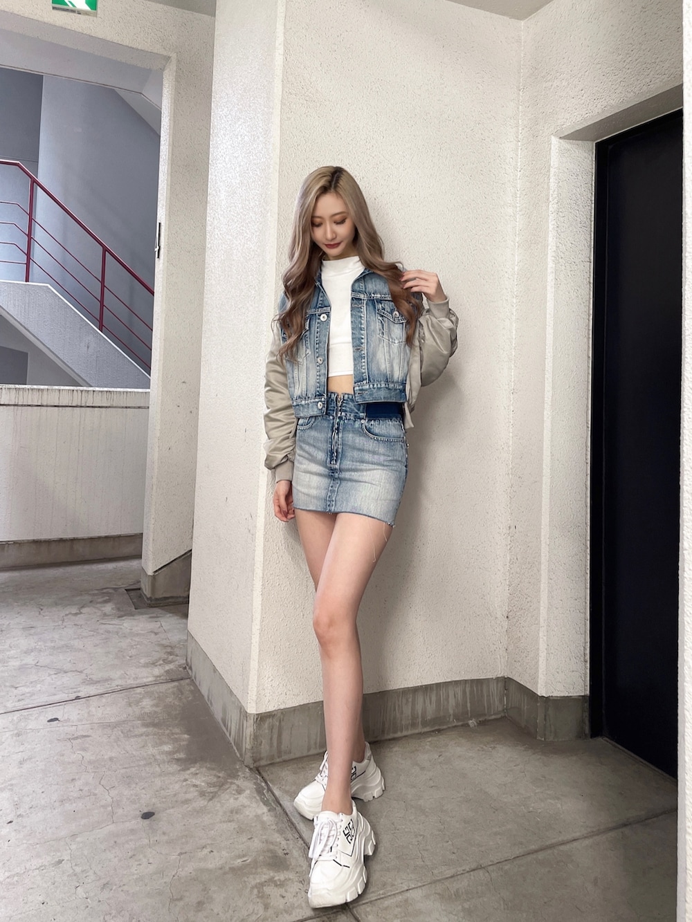 ブルー系のスカート、ブルー系のデニムジャケット、ホワイト系のTシャツ/カットソーを着用したレディースの秋コーディネートの2枚目の写真