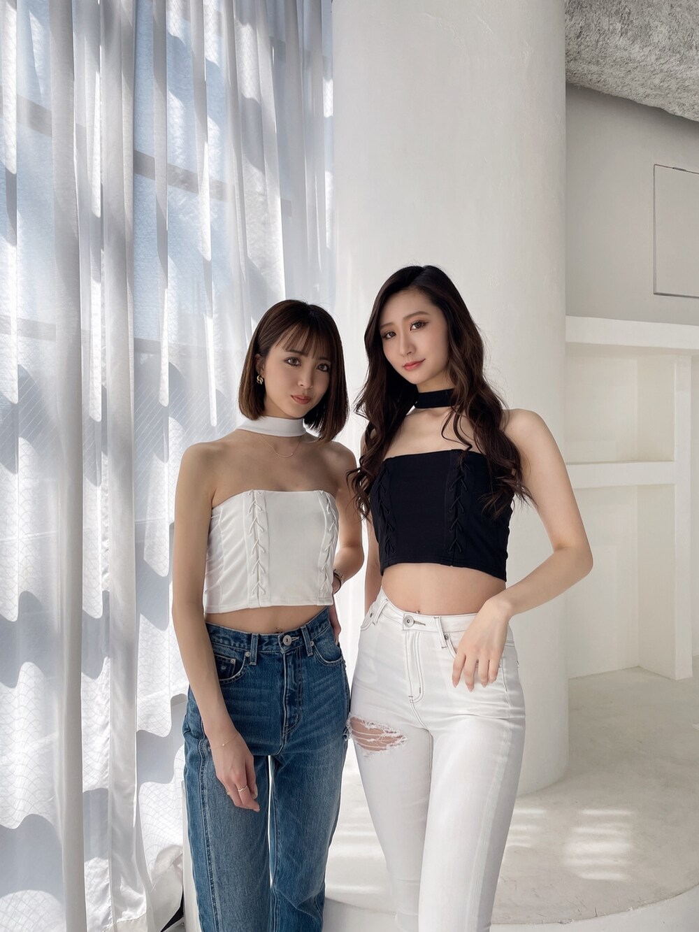 ブラック系のチューブトップ、ホワイト系のデニムパンツ、ブラック系のパンプスを着用したレディースの春コーディネートの3枚目の写真