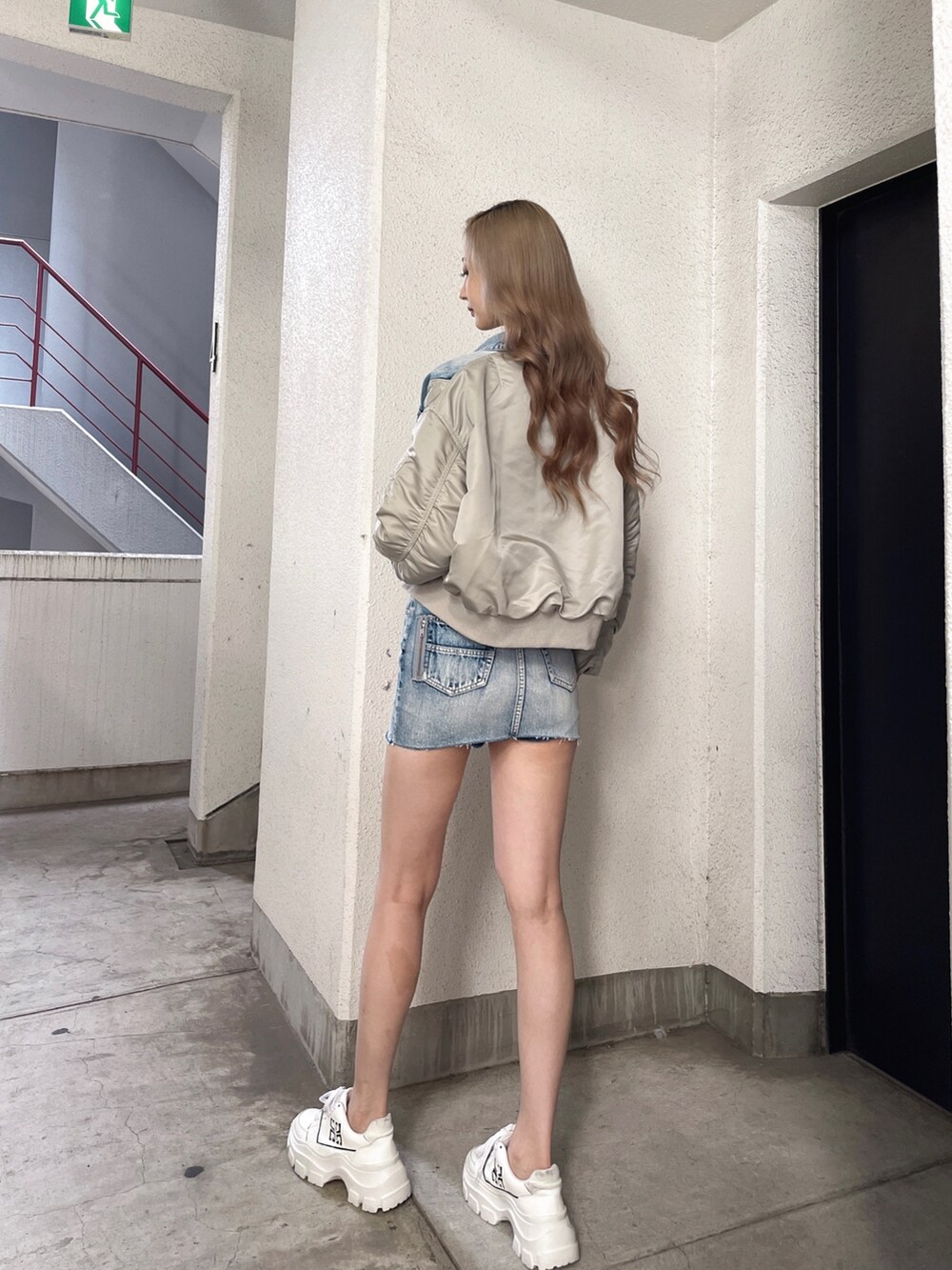 ブルー系のスカート、ブルー系のデニムジャケット、ホワイト系のTシャツ/カットソーを着用したレディースの秋コーディネートの3枚目の写真