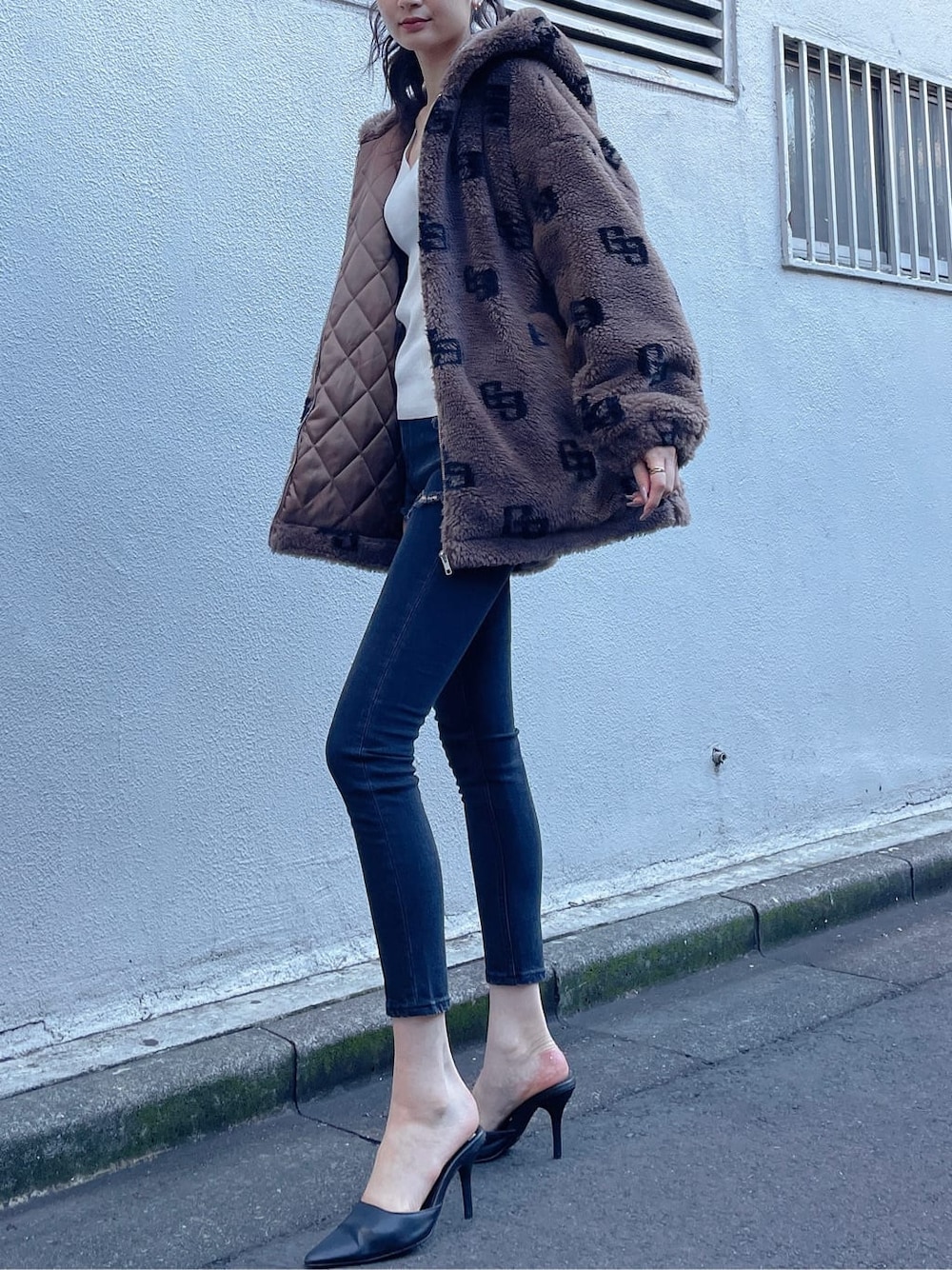 ブラック系のパンプス、ブラック系のデニムパンツ、ホワイト系のニット/セーターを着用したレディースの秋コーディネートの4枚目の写真