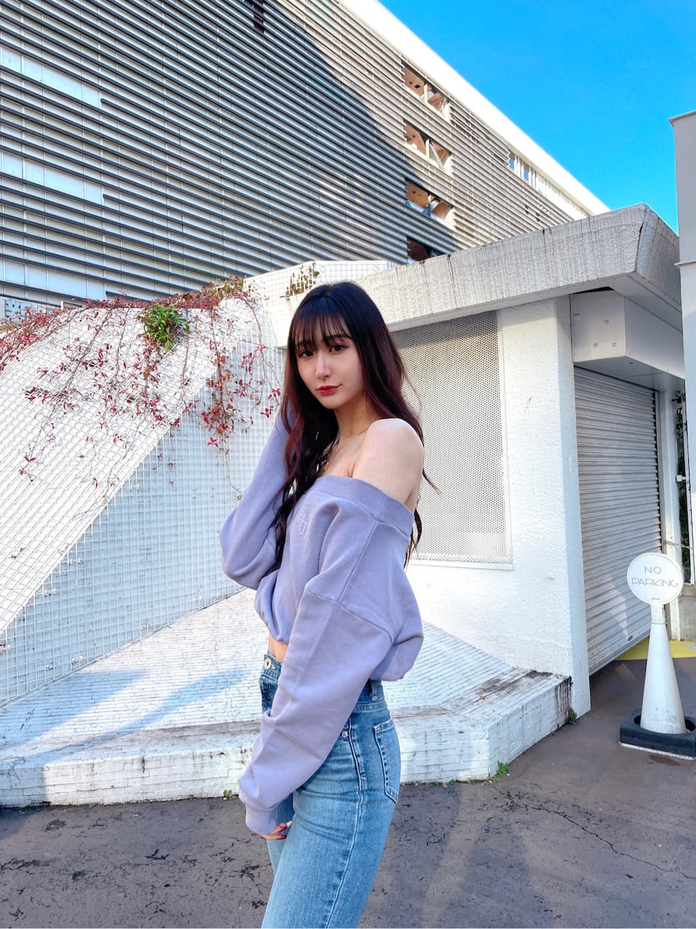 ホワイト系のパンプス、パープル系のスウェット、ブルー系のデニムパンツを着用したレディースの冬コーディネートの3枚目の写真