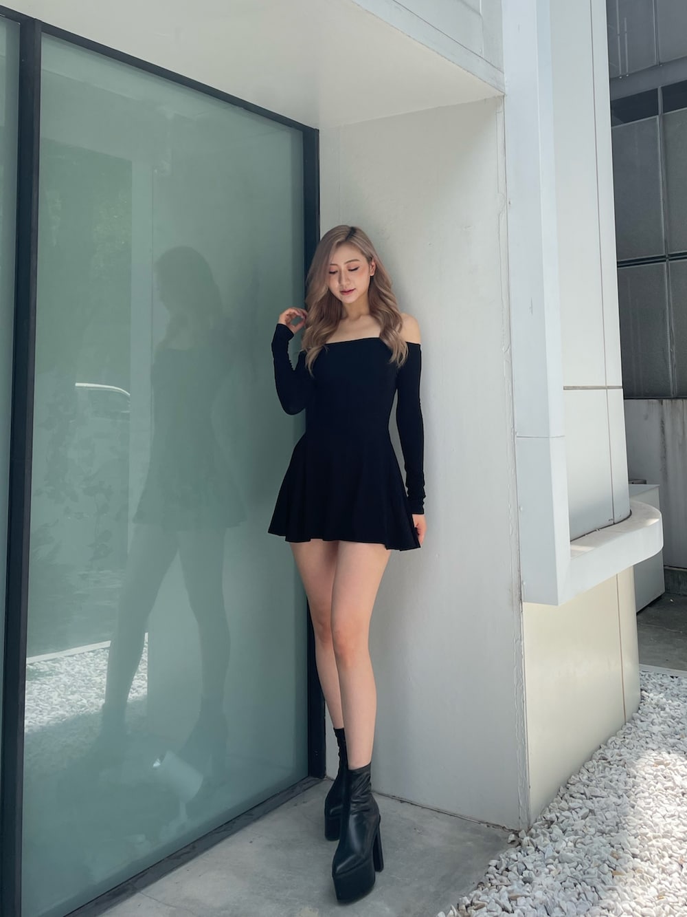 ブラック系のワンピース、ブラック系のブーツを着用したレディースの夏コーディネートの2枚目の写真