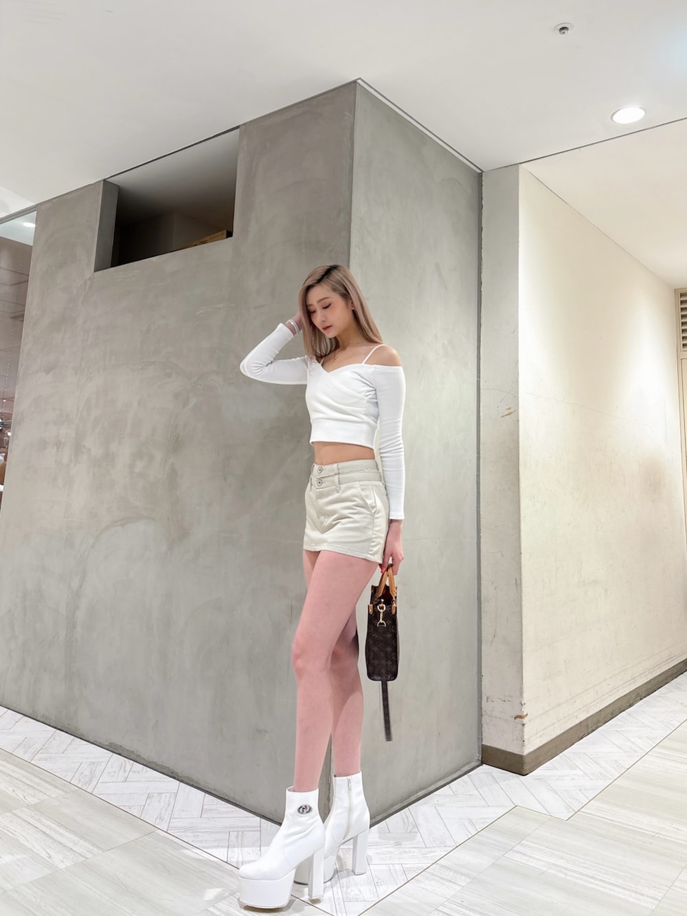 ホワイト系のスカート、ホワイト系のTシャツ/カットソー、ホワイト系のブーツを着用したレディースの春コーディネートの2枚目の写真