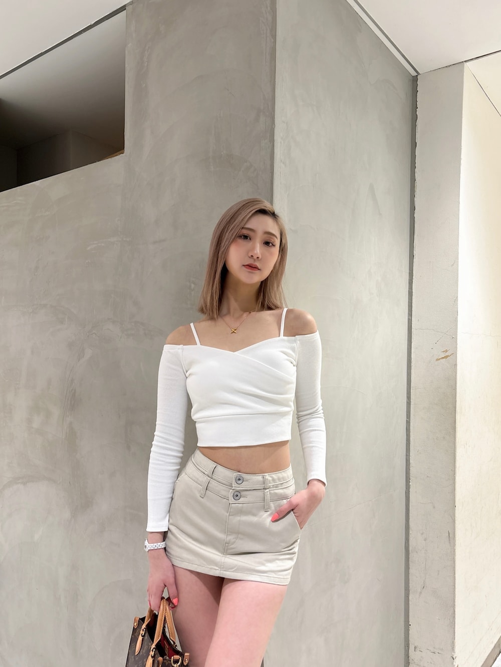 ホワイト系のスカート、ホワイト系のTシャツ/カットソー、ホワイト系のブーツを着用したレディースの春コーディネートの3枚目の写真