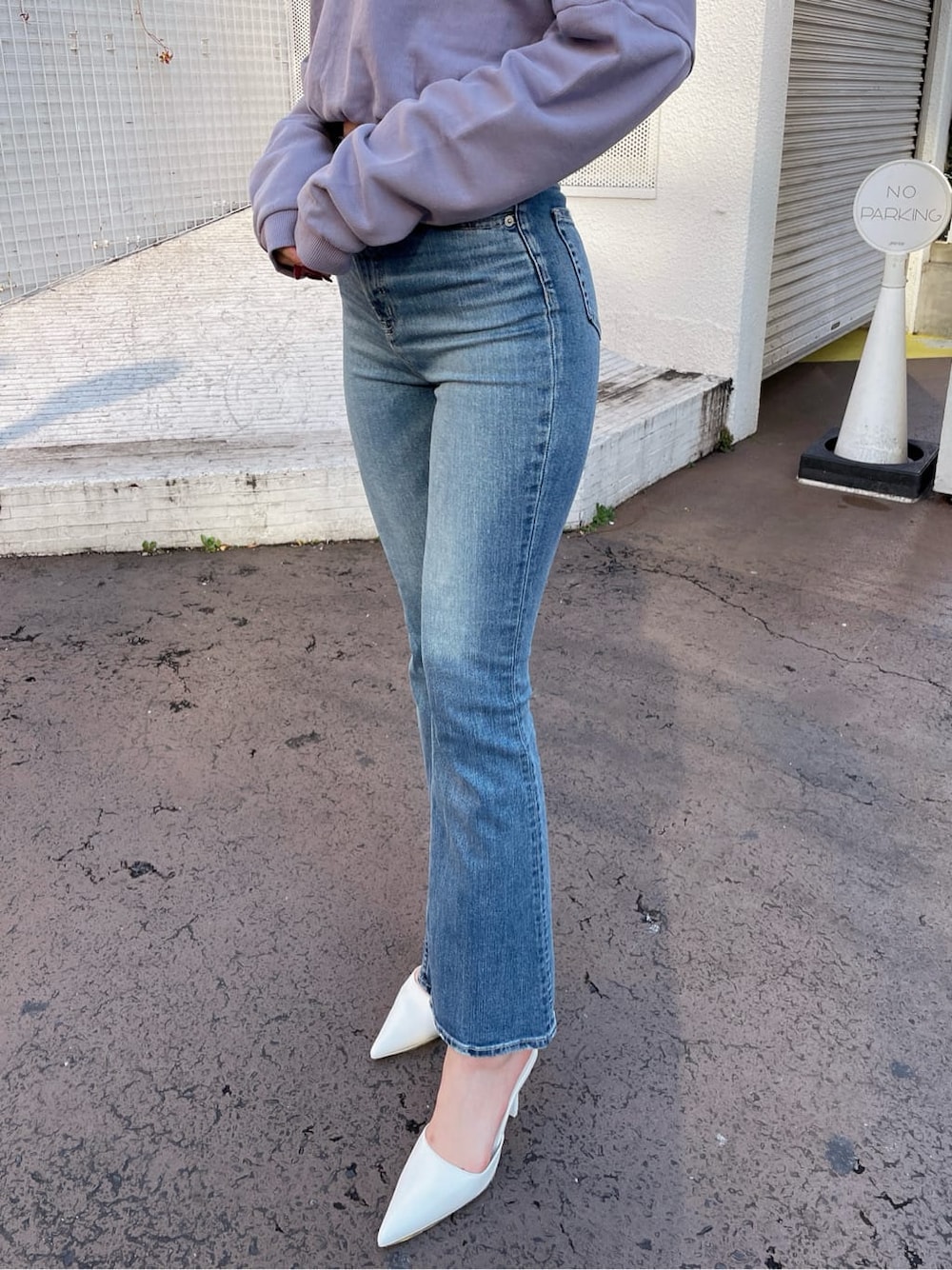 ホワイト系のパンプス、パープル系のスウェット、ブルー系のデニムパンツを着用したレディースの冬コーディネートの5枚目の写真