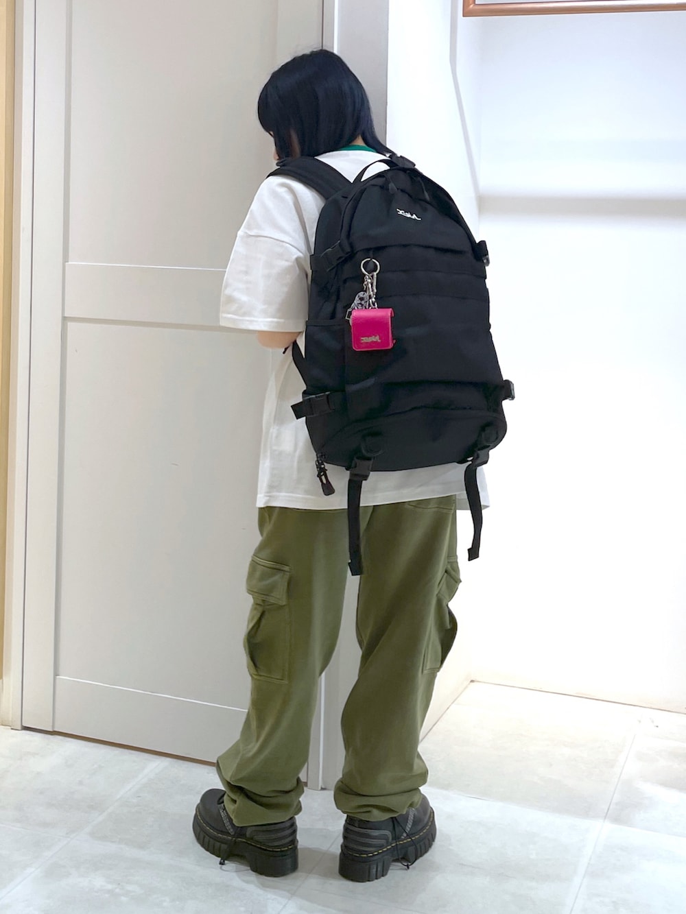 ブラック系のバックパック/リュック、グリーン系のスウェットパンツを着用したレディースの春コーディネートの2枚目の写真
