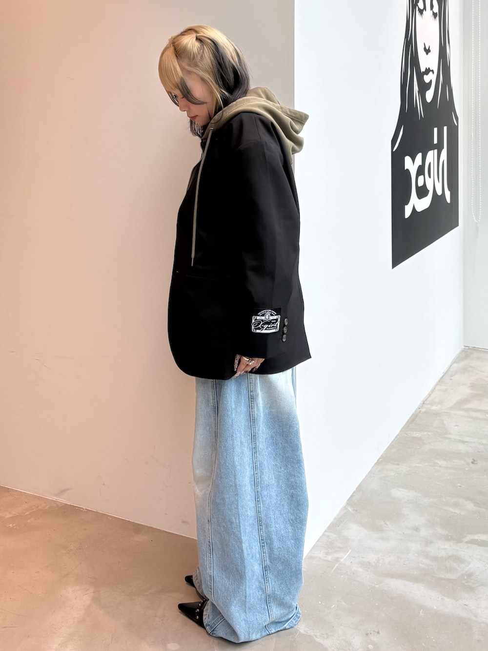 ブラック系のテーラードジャケット、ブルー系のデニムパンツ、ブラック系のTシャツ/カットソーを着用したレディースの春コーディネートの2枚目の写真