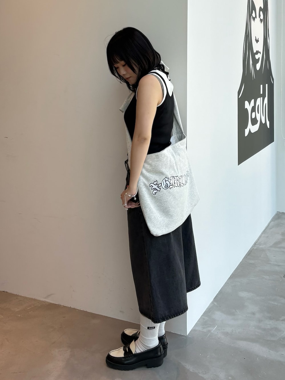 ブルー系のデニムパンツ、ベージュ系のキャミソール、グレー系のショルダーバッグを着用したレディースの春コーディネートの2枚目の写真