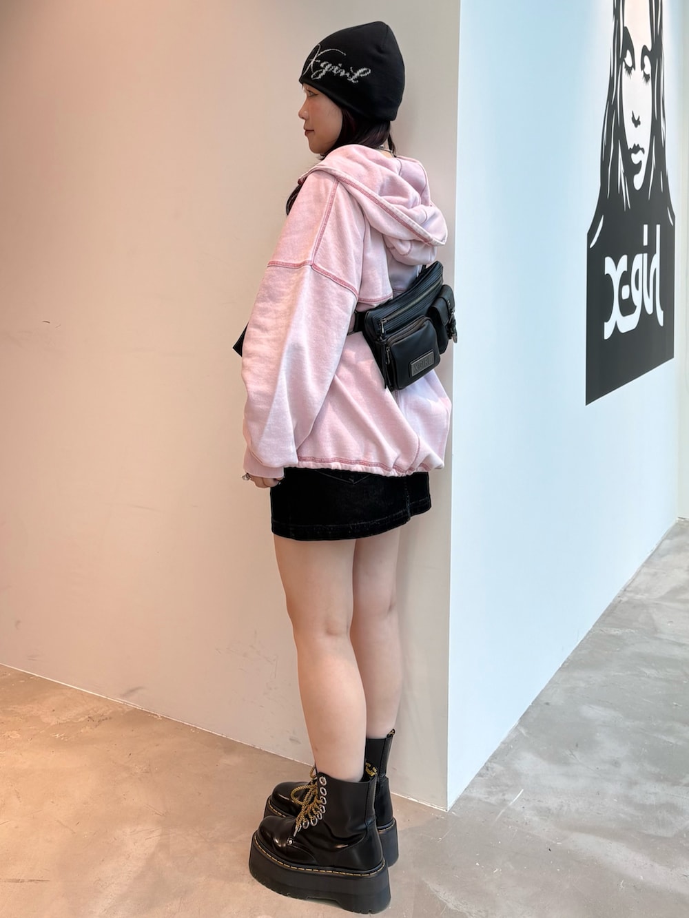 ピンク系のパーカー、ブルー系のデニムスカート、ブラック系のニットキャップ/ビーニーを着用したレディースの秋コーディネートの2枚目の写真