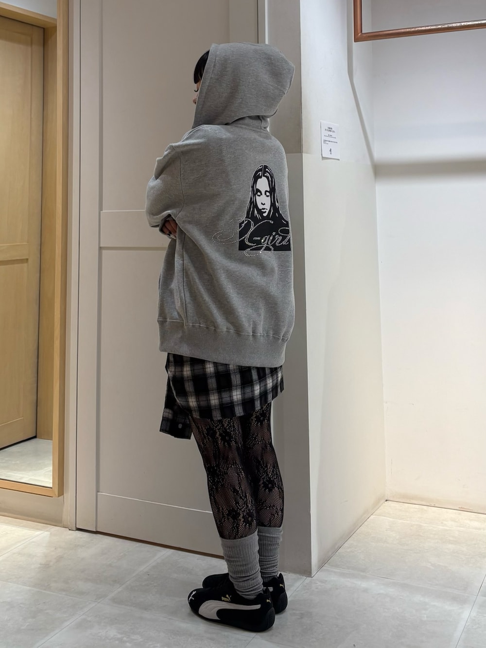 グレー系のパーカー、ブラック系のその他パンツを着用したレディースの冬コーディネートの2枚目の写真