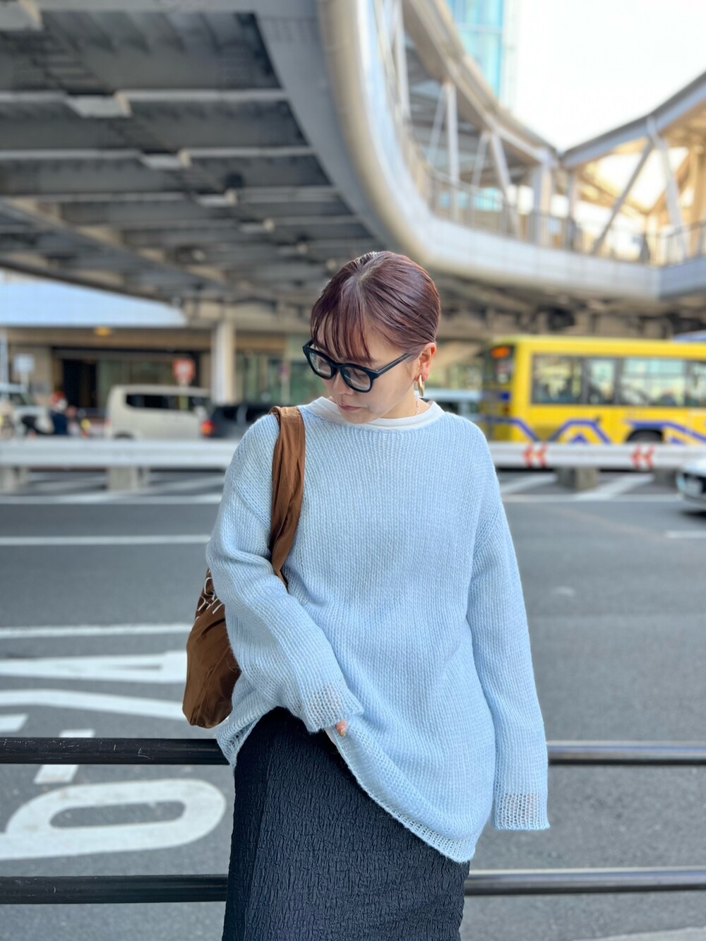 ブルー系のニット/セーター、ブラック系のスカート、ブラウン系のエコバッグ/サブバッグを着用したレディースの冬コーディネートの5枚目の写真