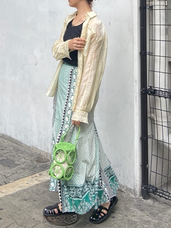 ブラック系のタンクトップ、ベージュ系のシャツ/ブラウス、グリーン系のスカートを着用したレディースの春コーディネートの3枚目の写真