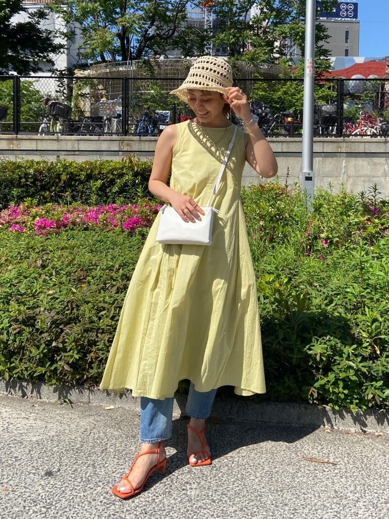 ブルー系のデニムパンツ、ホワイト系のシャツ/ブラウス、グリーン系のワンピースを着用したレディースの春コーディネートの2枚目の写真