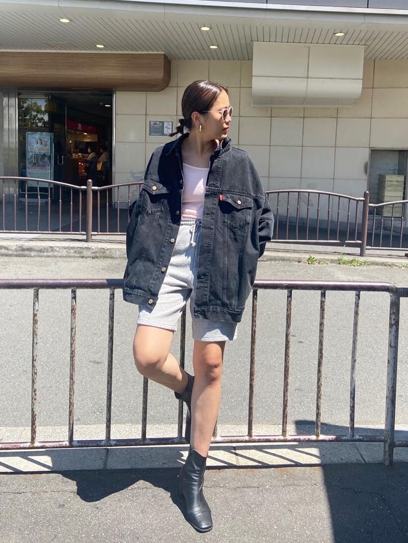 グレー系のスウェットパンツ、ピンク系のキャミソール、ブラック系のデニムジャケットを着用したレディースの秋コーディネートの2枚目の写真