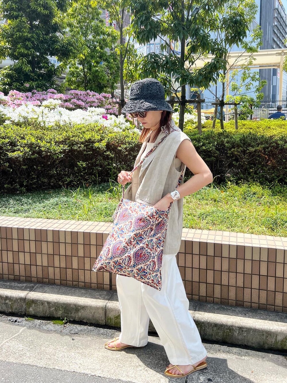 ホワイト系のその他パンツ、ベージュ系のテーラードジャケット、ゴールド系のサンダルを着用したレディースの春コーディネートの3枚目の写真