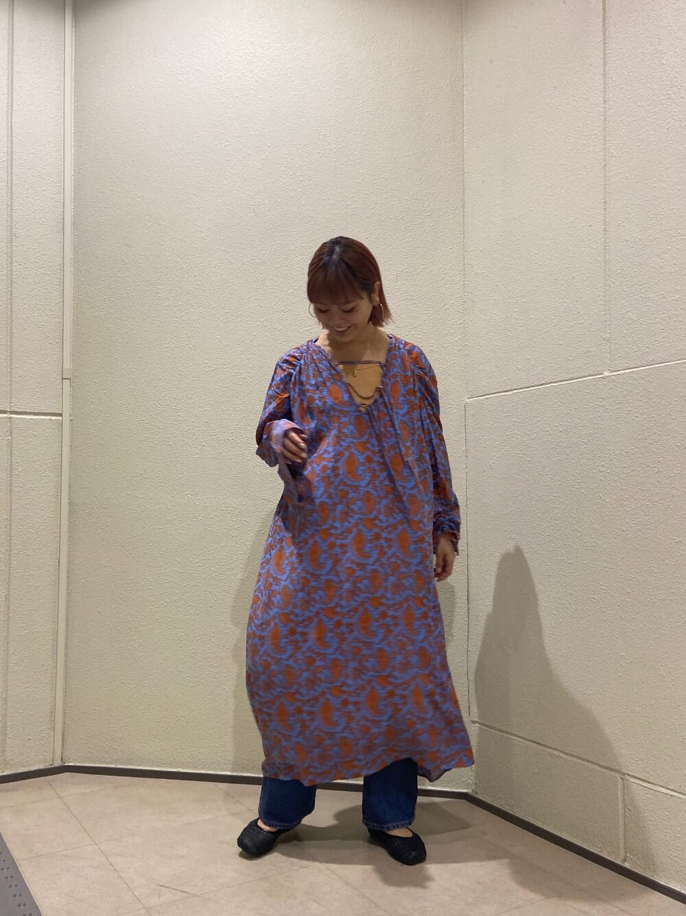 ブルー系のワンピース、ブラック系のパンプス、ホワイト系のハンドバッグを着用したレディースの冬コーディネートの3枚目の写真