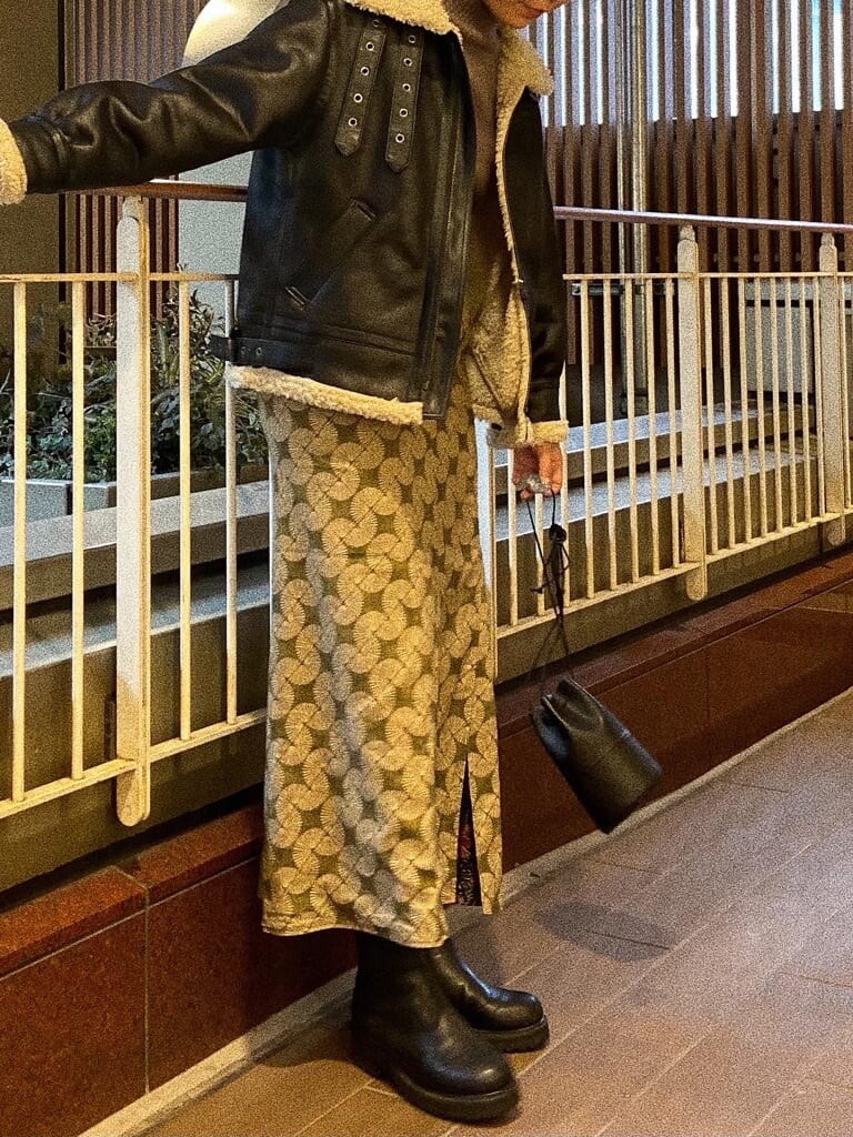 ブラック系のブルゾン、ブラック系のブーツ、ブラック系のハンドバッグを着用したレディースの秋コーディネートの2枚目の写真