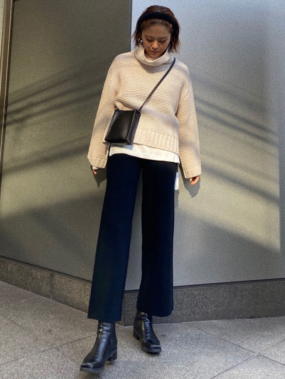 ホワイト系のTシャツ/カットソー、ブラック系のブーツ、ブラック系のその他パンツを着用したレディースの冬コーディネートの2枚目の写真