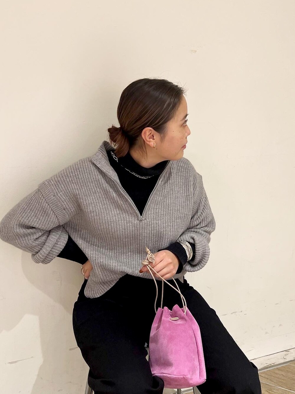 グレー系のニット/セーター、ブラック系のデニムパンツ、ブラック系のニット/セーターを着用したレディースの冬コーディネートの3枚目の写真