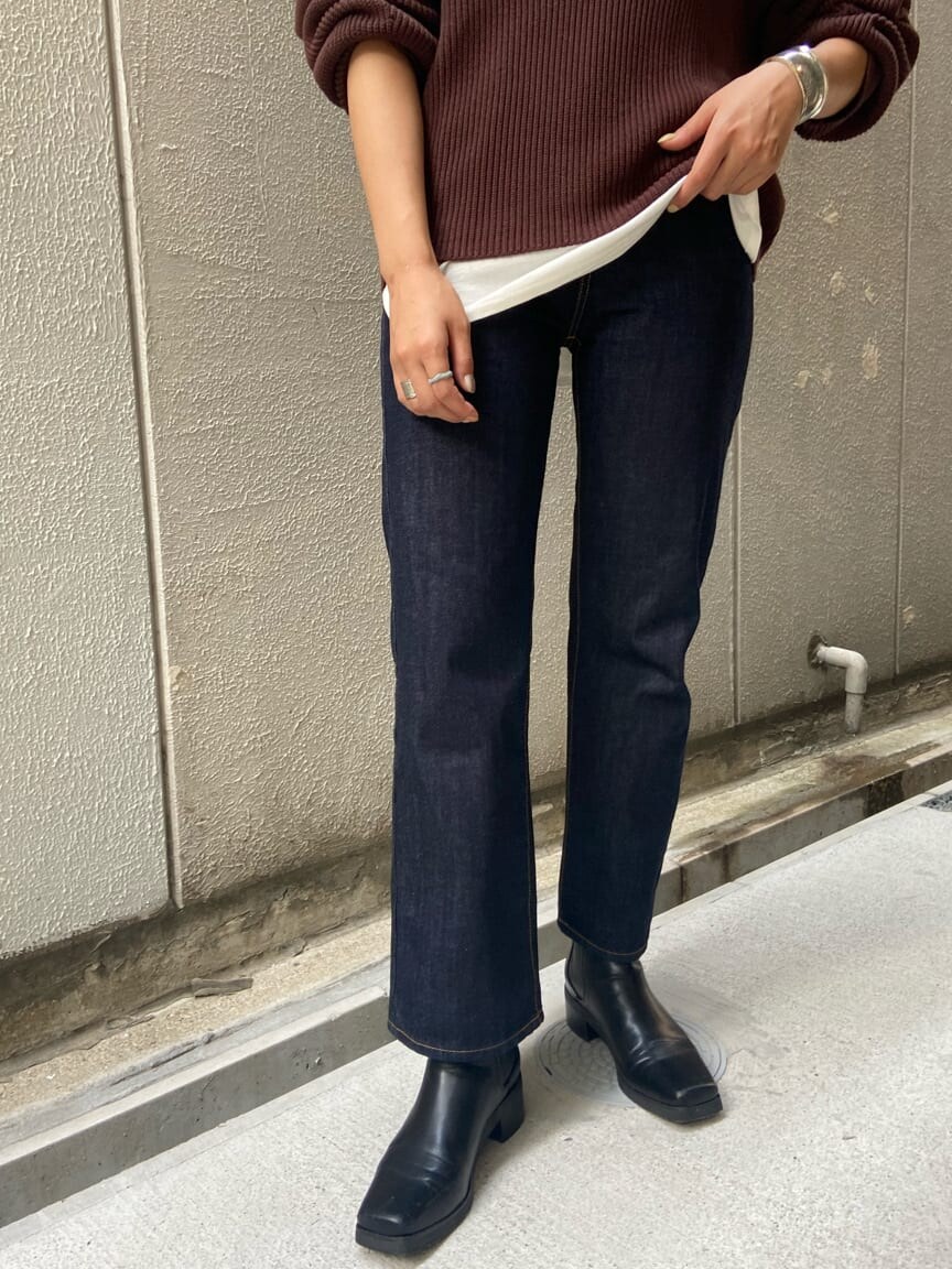 ブルー系のデニムパンツ、ブラウン系のニット/セーター、ホワイト系のTシャツ/カットソーを着用したレディースの夏コーディネートの2枚目の写真