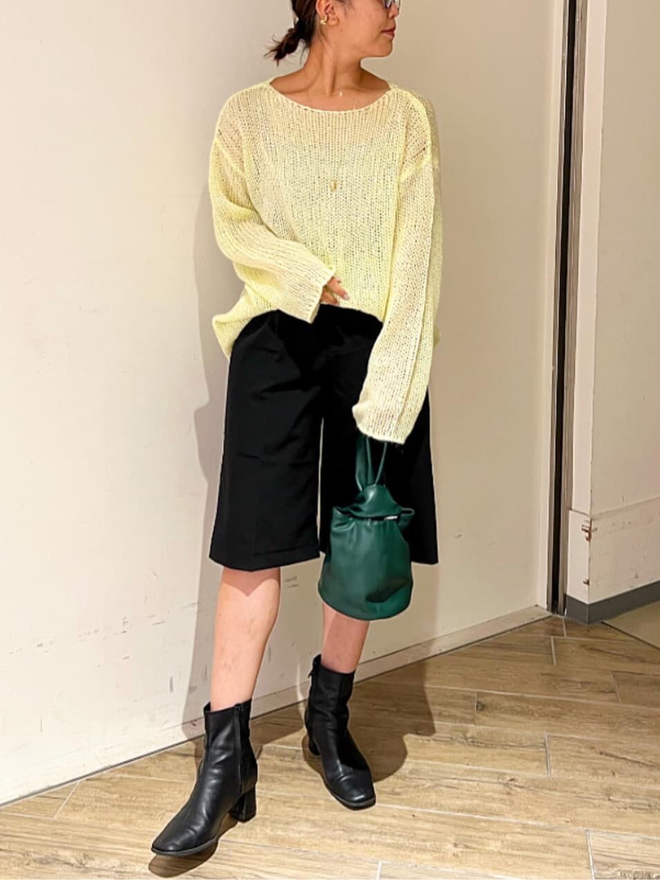 イエロー系のニット/セーター、ブラック系のその他パンツ、ブラック系のブーツを着用したレディースの秋コーディネートの3枚目の写真