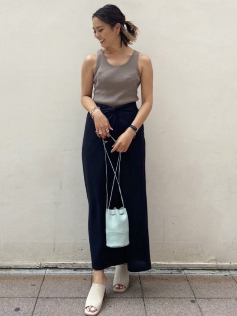 ベージュ系のサンダル、ブラック系のスカート、グレー系のタンクトップを着用したレディースの夏コーディネートの2枚目の写真