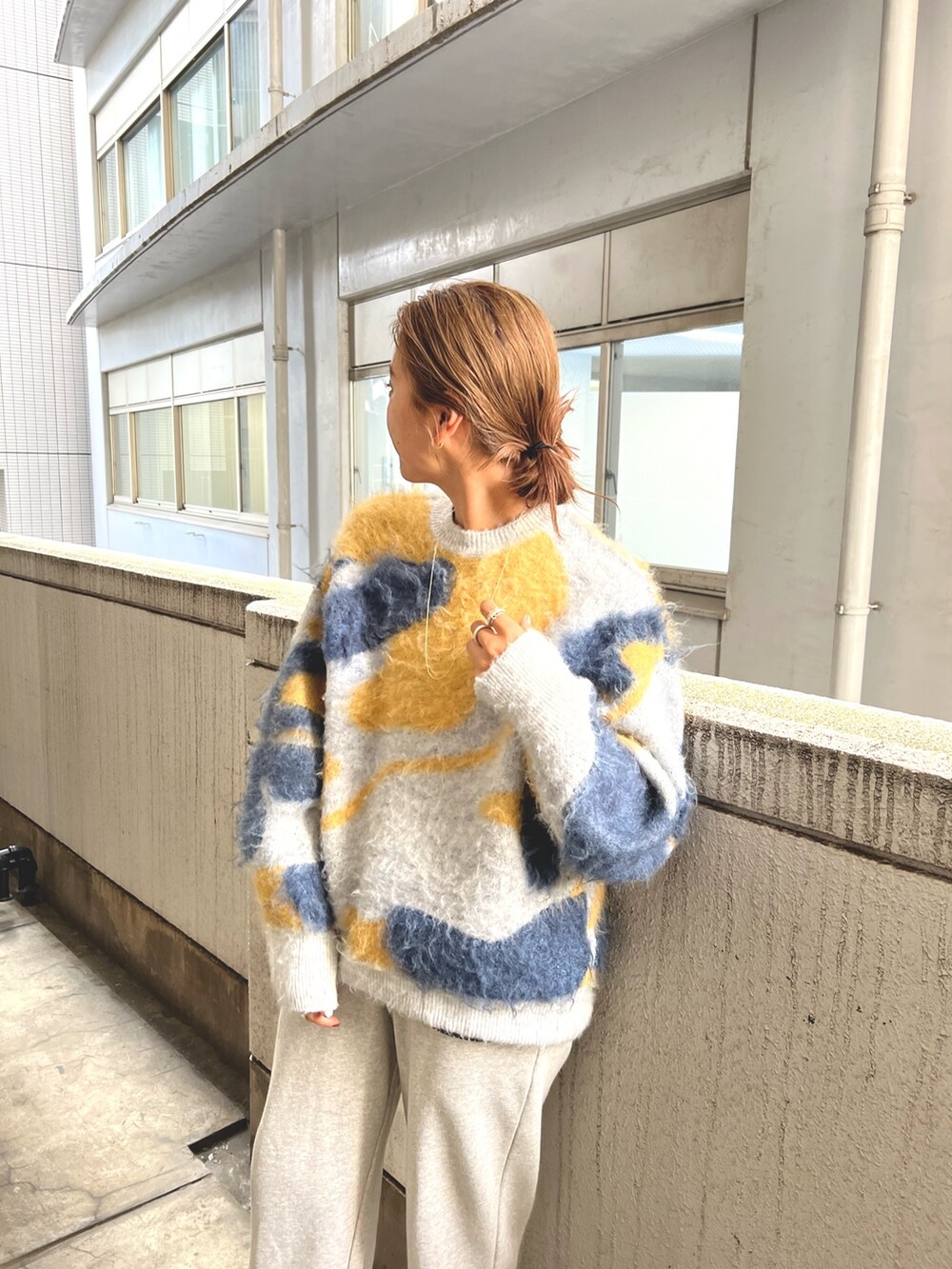 ブルー系のニット/セーター、グレー系のスウェットパンツを着用したレディースの夏コーディネートの2枚目の写真