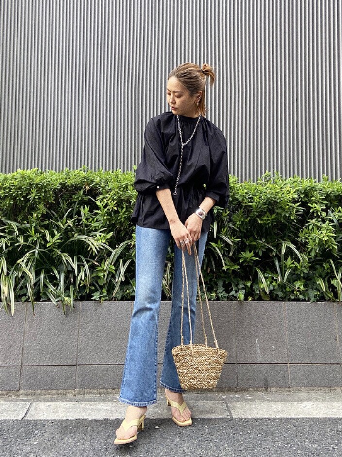 グリーン系のサンダル、ベージュ系のかごバッグ、ブラック系のシャツ/ブラウスを着用したレディースの春コーディネートの2枚目の写真